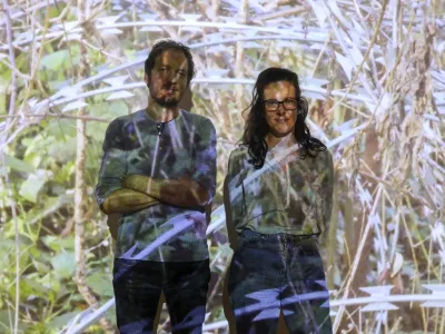 Vizualna umetnica Nika Autor in Goran Lukić iz Delavske svetovalnice pred videom o rezilnih žicah z razstave Če bi gozdovi govorili, bi se od žalosti posu&scaron;ili&nbsp;