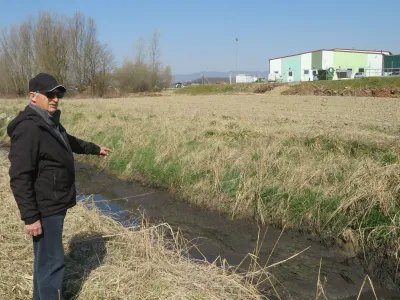 &raquo;Že lani smo začeli opažati, da se v kanalu, tik ob sprehajalni poti po nasipu, nabira blato, ki močno zaudarja,&laquo; pravi Stanko Savnik, predsednik Brodarsko turističnega dru&scaron;tva Mostec. V ozadju breži&scaron;ka čistilna naprava.&nbsp;