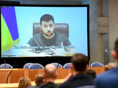 Ukrainian President Volodymyr Zelenskiy appears on screen as he addresses the members of Dutch parliament via video link, amid Russia's invasion of Ukraine, in The Hague, Netherlands, March 31, 2022. REUTERS/Piroschka Van De Wouw