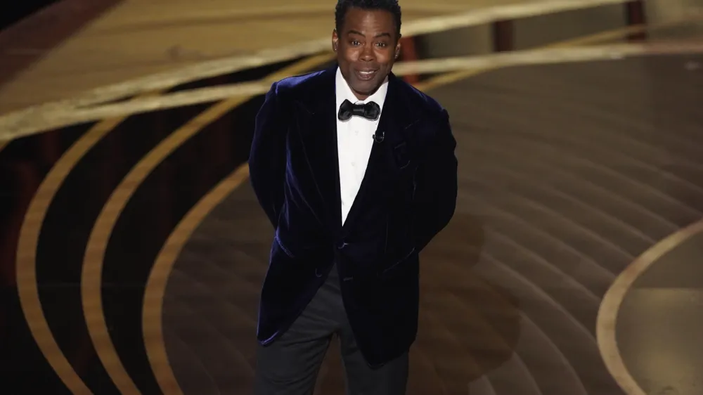 Chris Rock presents the award for best documentary feature at the Oscars on Sunday, March 27, 2022, at the Dolby Theatre in Los Angeles. (AP Photo/Chris Pizzello)