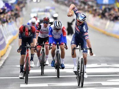 Netherland's Mathieu Van Der Poel of the Alpecin Fenix team, right, crosses the finish line to win the Ronde van Vlaanderen in Oudenaarde, Belgium, Sunday, April 3, 2022. (AP Photo/Geert Vanden Wijngaert)