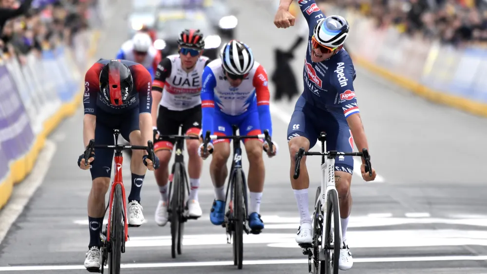 Netherland's Mathieu Van Der Poel of the Alpecin Fenix team, right, crosses the finish line to win the Ronde van Vlaanderen in Oudenaarde, Belgium, Sunday, April 3, 2022. (AP Photo/Geert Vanden Wijngaert)
