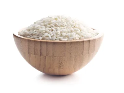 The arborio rice in wooden bowl. Isolated on white background.