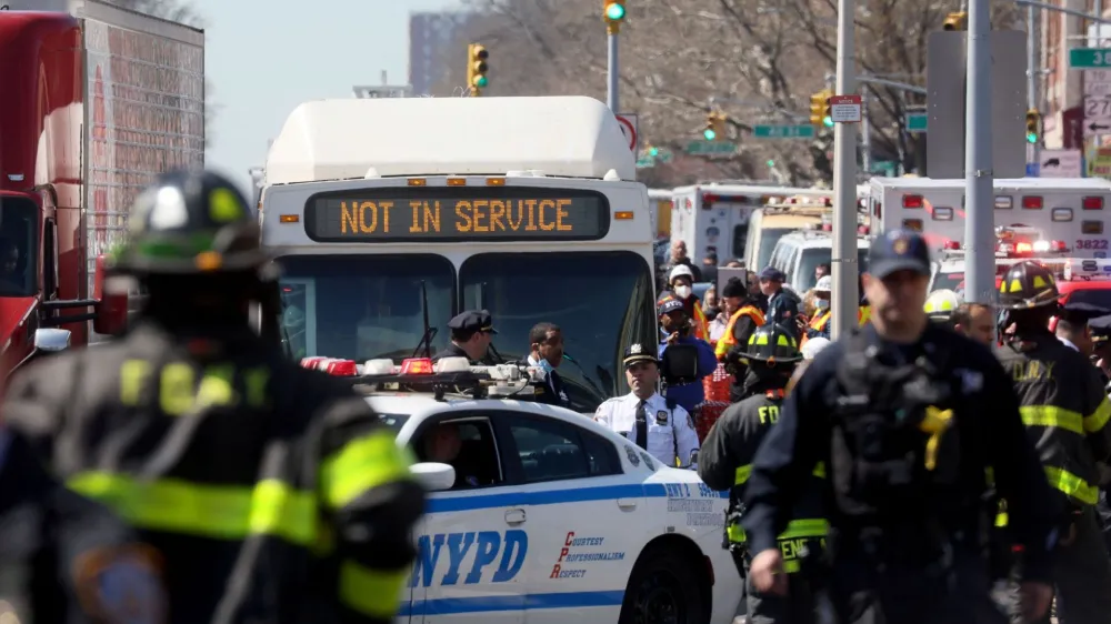Law enforcement officers and firefighters work near the scene of a shooting at a subway station in the Brooklyn borough of New York City, New York, U.S., April 12, 2022. REUTERS/Brendan McDermid