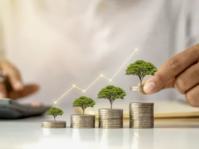 A businessman holding a coin with a tree that grows and a tree that grows on a pile of money. The idea of maximizing the profit from the business investment.