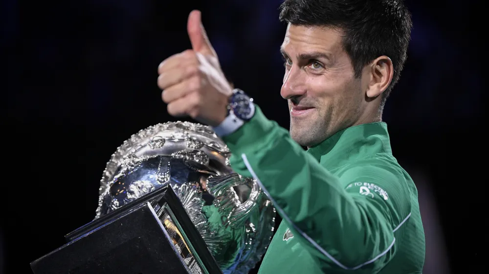Serbia's Novak Djokovic gestures as he holds the Norman Brookes Challenge Cup after defeating Austria's Dominic Thiem in the final of the Australian Open tennis championship in Melbourne, Australia, Monday, Feb. 3, 2020. (AP Photo/Andy Brownbill)