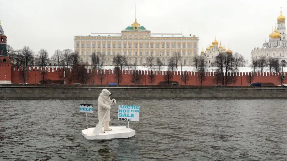 Wearing a costume of polar bear a Greenpeace activist takes part in a staged show on the Moskva River in front of the Kremlin in Moscow on April 1, 2013. According to Greenpeace the staged show was aimed to draw attention to the threats of the catastrophic climate consequences of Arctic oil drilling. AFP PHOTO / ANDREY SMIRNOV