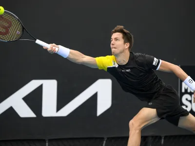 Slovenia's Aljaz Bedene makes a forehand return to Japan's Yasutaka Uchiyama during a tuneup tournament ahead of the Australian Open tennis championships in Melbourne, Australia, Monday, Feb. 1, 2021. (AP Photo/Andrew Brownbill)
