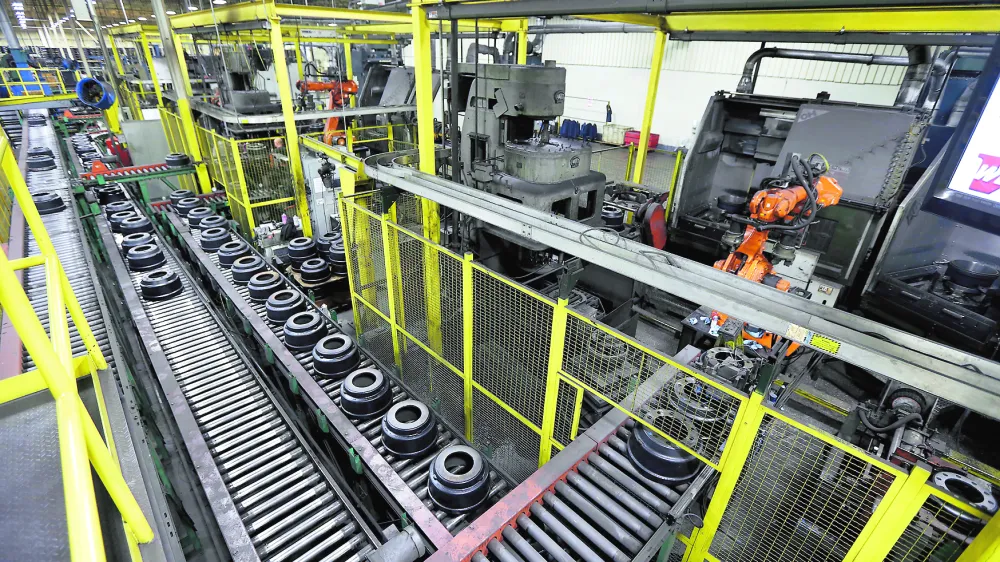 In this Friday, Jan. 11, 2013, photo, brake drums roll down a conveyor belt to a station which robotically balances the drum at Webb Wheel Products in Cullman, Ala. Webb Wheel hasn't added a factory worker in three years, though it's making 300,000 more drums annually, a 25 percent increase, because of robots. (AP Photo/Dave Martin)