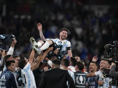 Argentina's players celebrate with Lionel Messi, top, after winning the Finalissima soccer match between Italy and Argentina at Wembley Stadium in London, Wednesday, June 1, 2022. (AP Photo/Matt Dunham)