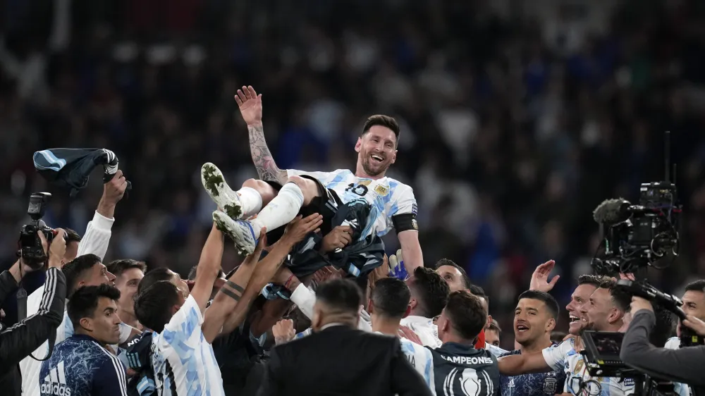 Argentina's players celebrate with Lionel Messi, top, after winning the Finalissima soccer match between Italy and Argentina at Wembley Stadium in London, Wednesday, June 1, 2022. (AP Photo/Matt Dunham)
