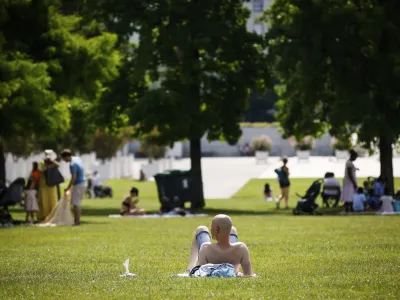 A man sunbathes in a park Saturday, June 18, 2022 in Paris. A blanket of hot air stretching from the Mediterranean to the North Sea is bringing much of Western Europe its first heat wave of the summer, with temperatures exceeding 30 degrees Celsius (86 degrees Fahrenheit). (AP Photo/Thomas Padilla)