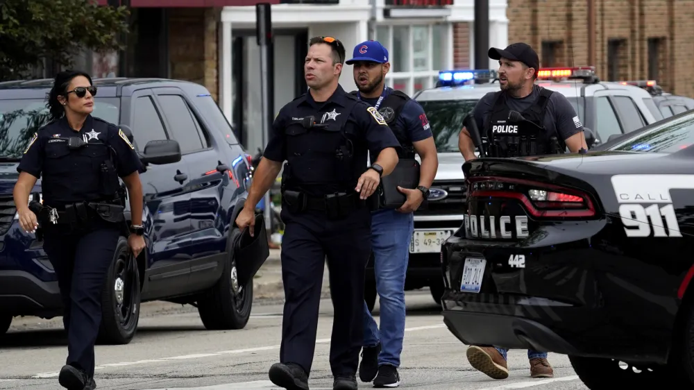 Police search the downtown area in Highland Park after a shooting at a Fourth of July parade, Monday, July 4, 2022. (AP Photo/Nam Y. Huh)
