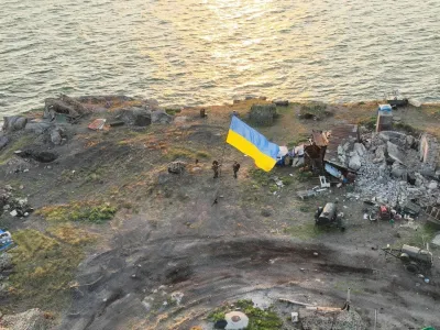 Ukrainian service members install a national flag on Snake (Zmiinyi) Island, as Russia's attack on Ukraine continues, in Odesa region, Ukraine, in this handout picture released July 7, 2022. Press service of the Ukrainian Armed Forces/Handout via REUTERS ATTENTION EDITORS - THIS IMAGE HAS BEEN SUPPLIED BY A THIRD PARTY.