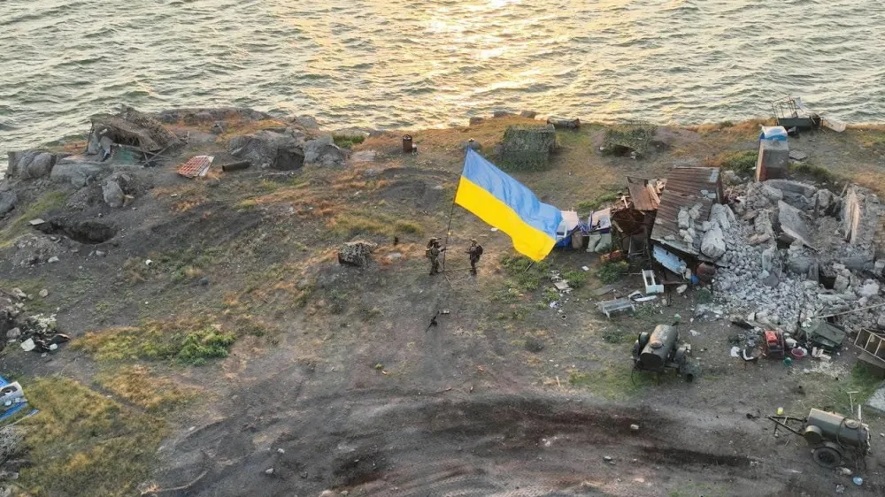 Ukrainian service members install a national flag on Snake (Zmiinyi) Island, as Russia's attack on Ukraine continues, in Odesa region, Ukraine, in this handout picture released July 7, 2022. Press service of the Ukrainian Armed Forces/Handout via REUTERS ATTENTION EDITORS - THIS IMAGE HAS BEEN SUPPLIED BY A THIRD PARTY.
