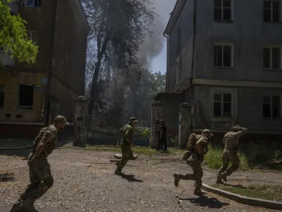 FILE - Ukrainian soldiers run after a missile strike hit a residential area, in Kramatorsk, Donetsk region, eastern Ukraine, Thursday, July 7, 2022. Injured residents sat dazed and covered in blood. A crater was now the centre of the courtyard. Last week, the governor of the Donetsk oblast Pavlo Kyrylenko urged the province's more than 350,000 remaining residents to flee to safer towns further West, saying that evacuating the region was necessary to save lives and allow the Ukrainian army to better defend towns against a Russian advance. Many refuse to leave the city. (AP Photo/Nariman El-Mofty, File)