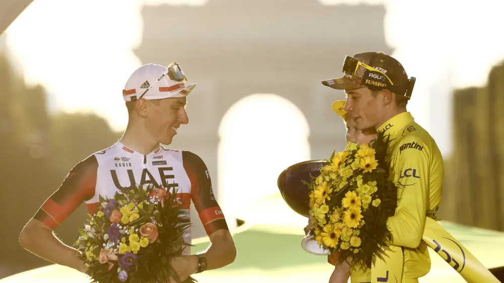 Cycling - Tour de France - Stage 21 - Paris La Defense Arena to Champs-Elysees - France - July 24, 2022 Jumbo - Visma's Jonas Vingegaard celebrates on the podium wearing the overall leader's yellow jersey after winning the Tour de France with second placed UAE Team Emirates' Tadej Pogacar REUTERS/Christian Hartmann