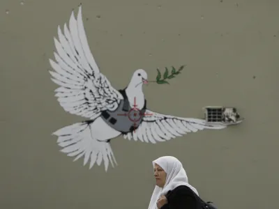 A work by English graffiti artist Banksy is seen on a wall in the West Bank town of Bethlehem, Friday, Dec. 21, 2007. Two other works by the British artist in the biblical West Bank town were defaced by locals after some found the work offensive, Palestinian sources said. (AP Photo/Kevin Frayer)
