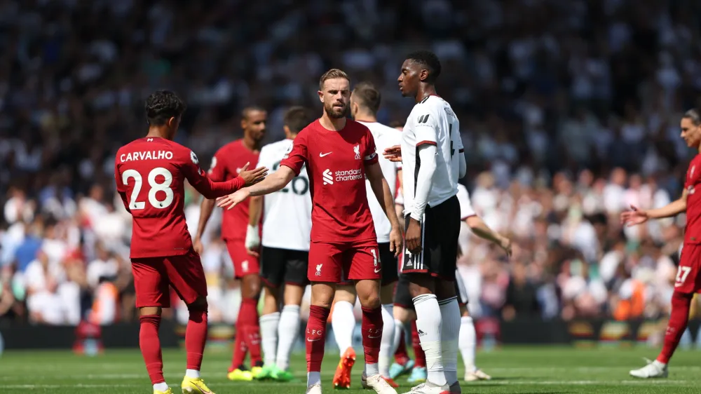 Liverpool's Fabio Carvalho, left, greets teammate Liverpool's Jordan Henderson at the end of the English Premier League soccer match between Fulham and Liverpool at Craven Cottage stadium in London, Saturday, Aug. 6, 2022. (AP Photo/Ian Walton)