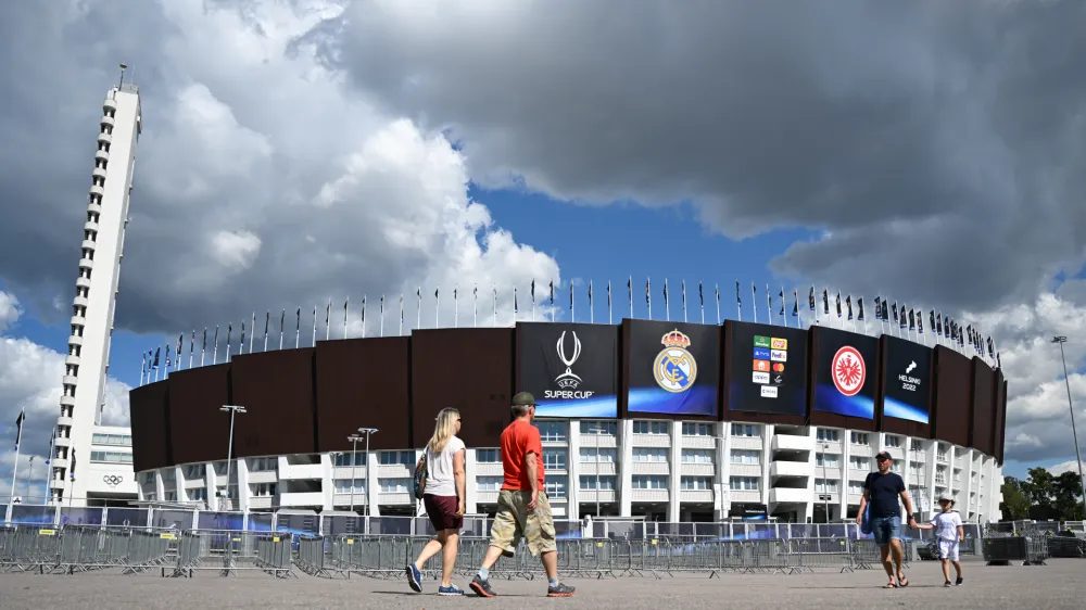 09 August 2022, Finland, Helsinki: People walk past the Olympic Stadium, host venue of Wednesday's UEFA Super Cup soccer match between Real Madrid and Eintracht Frankfurt. Photo: Arne Dedert/dpa