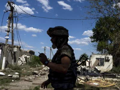 A Ukrainian serviceman walks on a street at the frontline in Mykolaiv region, Ukraine, on Monday, Aug. 8, 2022. (AP Photo/Evgeniy Maloletka)
