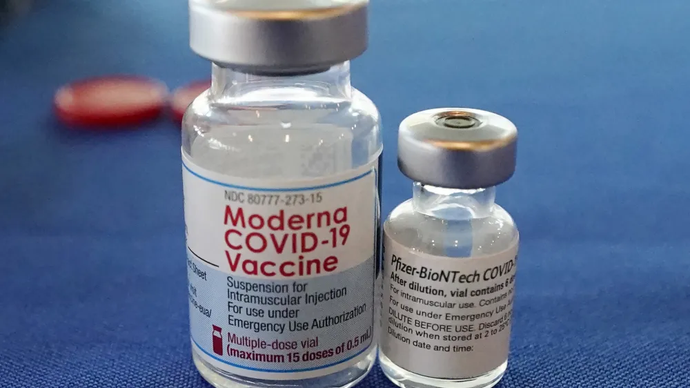 FILE - This Sept. 21, 2021 file photo shows vials of the Pfizer and Moderna COVID-19 vaccines in Jackson, Miss. Moderna is suing its main competitors Pfizer and the German drugmaker BioNTech, accusing the rivals of copying Moderna's technology in order to make their own vaccine. Moderna said Friday, Aug. 26, 2022, that Pfizer and BioNTech's vaccine Comirnaty infringes on patents Moderna filed several years ago protecting the technology behind its preventive shot, Spikevax. (AP Photo/Rogelio V. Solis, File)