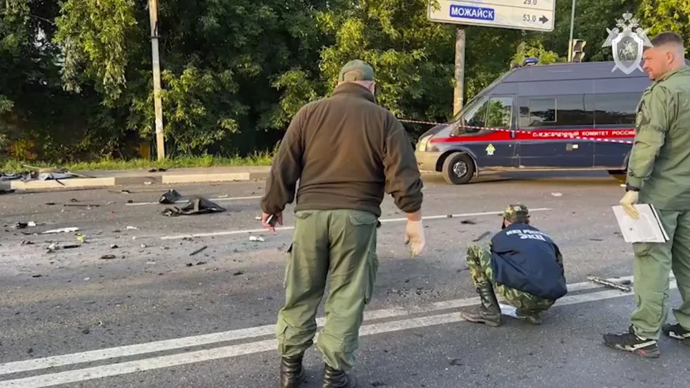 In this handout photo taken from video released by Investigative Committee of Russia on Sunday, Aug. 21, 2022, investigators work on the site of explosion of a car driven by Daria Dugina outside Moscow. Daria Dugina, the daughter of Alexander Dugin, the Russian nationalist ideologist often called "Putin's brain", was killed when her car exploded on the outskirts of Moscow, officials said Sunday. The Investigate Committee branch for the Moscow region said the Saturday night blast was caused by a bomb planted in the SUV driven by Daria Dugina.(Investigative Committee of Russia via AP)