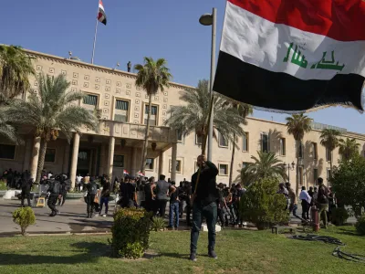 Supporters of Shiite cleric Muqtada al-Sadr demonstrate in the grounds of the Government Palace in Baghdad, Iraq, Monday, Aug. 29, 2022. Al-Sadr, a hugely influential Shiite cleric announced he will resign from Iraqi politics and his angry followers stormed the government palace in response. The chaos Monday sparked fears that violence could erupt in a country already beset by its worst political crisis in years. (AP Photo/Hadi Mizban)