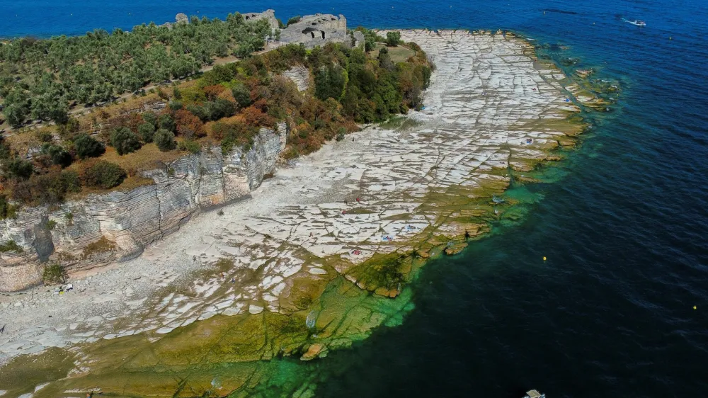 Pogled na italijansko jezero Garda, kjer so zaradi na povr&scaron;ju marsikje skale. 