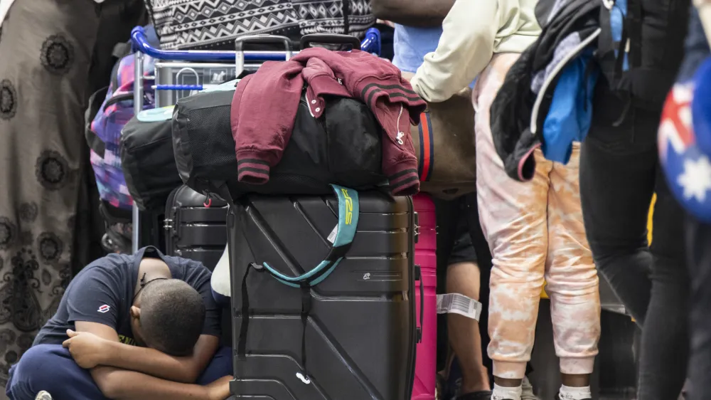 02 September 2022, Hessen, Frankfurt: A boy sits next to his family's suitcases at the Lufthansa rebooking counter in Frankfurt Airport. Numerous Lufthansa flights have been cancelled due to the all-day pilots' strike by the Vereinigung Cockpit union. Photo: Boris Roessler/dpa
