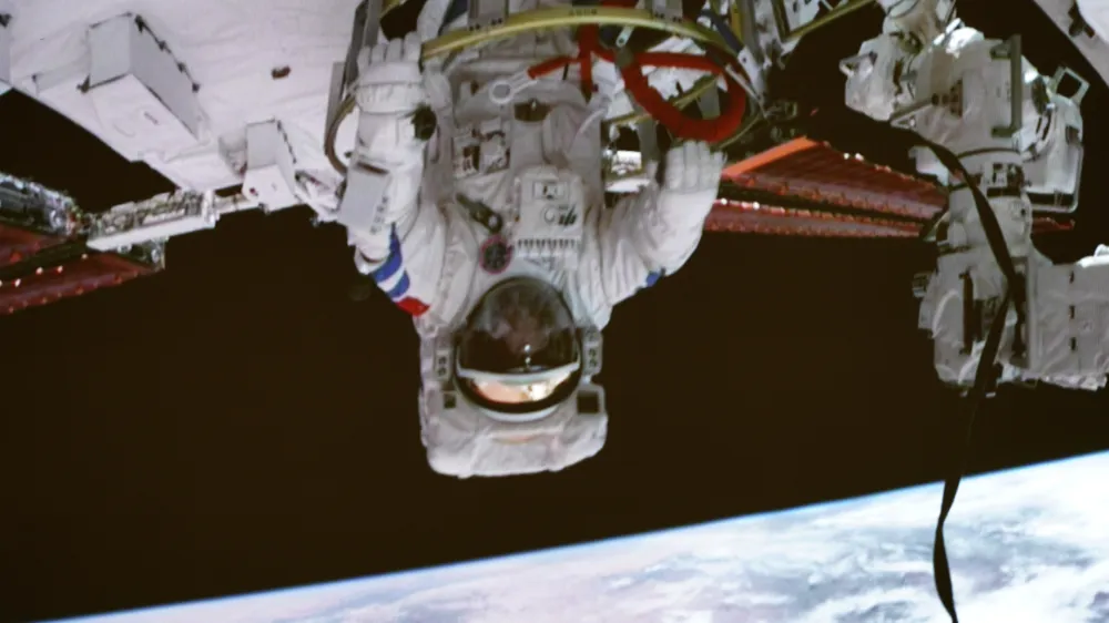 In this photo released by Xinhua News Agency, screen image captured at the Beijing Aerospace Control Center on Sept. 1, 2022 shows Shenzhou-14 astronaut Chen Dong exiting the space station lab module Wentian orbiting earth. The Shenzhou 14 Chinese space crew started a series of extravehicular activities on Thursday evening, according to space media reports. (Li Jie/Xinhua via AP)