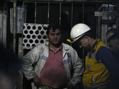 Miners and rescue members wait in front of the mine in Amasra, in the Black Sea coastal province of Bartin, Turkey, Saturday, Oct. 15, 2022. Officials say a deadly explosion occurred inside a coal mine in northern Turkey, trapping dozens of miners. (AP Photo/Khalil Hamra)