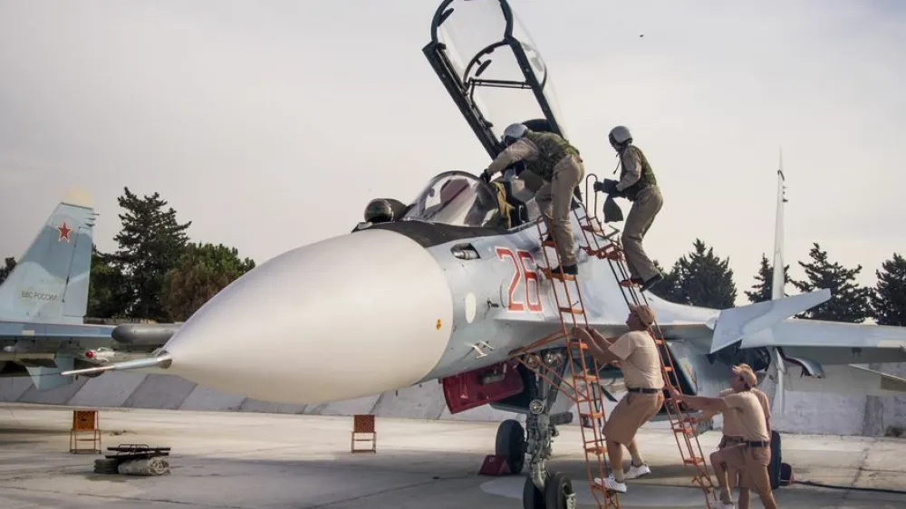 FILE - In this file photo taken on Thursday, Oct. 22, 2015, Russian air force pilots assisted by ground crew climb into their fighter jet at Hemeimeem airbase, Syria. (AP Photo/Vladimir Isachenkov, File)