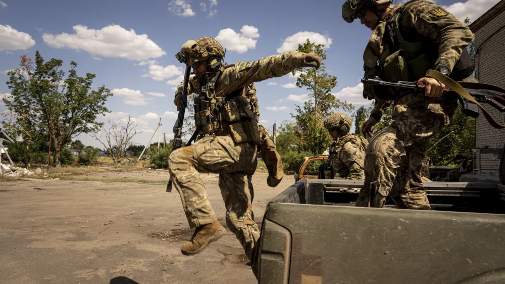 FILE - Ukrainian servicemen of "Fireflies" reconnaissance team jump from the trunk of pickup to take their position at the frontline in Mykolaiv region, Ukraine, Aug. 8, 2022. During the summer, Ukrainian troops launched relentless attacks to reclaim parts of the province, also called Kherson and one of four regions that Russia illegally annexed after sham referendums last month. Ukrainian forces pressing an offensive in the south have zeroed in on Kherson, a provincial capital that has been under Russian control since the early days of the invasion. (AP Photo/Evgeniy Maloletka, File)