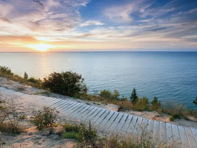 A colorful sunset over Lake Michigan shines its light on this boardwalk on Empire Bluff Trail near Empire Michigan. This trail overlooks Sleeping Bear Dunes