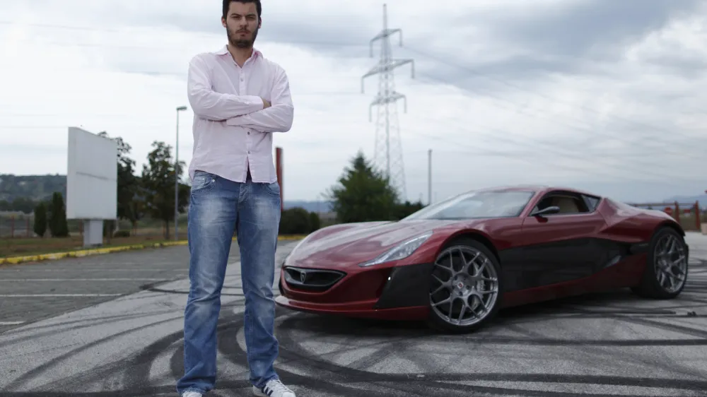Mate Rimac owner of Rimac Automobili poses with the Concept One car in Zagreb August 31, 2012. Croatian concept car manufacturer Rimac Automobili based near Zagreb prepares to unveil a prototype of their Concept One electric supercar at the upcoming Salon Priv&eacute; car show in London in early September.The Concept One has a carbon fiber body an electric motor powering each wheel, and can produce 1,088 horse powers, capable of achieving top speed of around 305 kmh (190 mph) with a range of 600 kilometres (373 miles), making it the world's fastest electric car. Costing around $1 million each, only 13 of these high-end electric cars are expected to be produced per year. Picture taken August 31, 2012. REUTERS/Antonio Bronic (CROATIA - Tags: TRANSPORT BUSINESS) - RTR37CTI