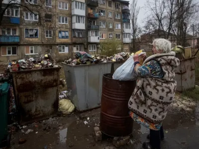 A local resident takes out a trash bag, as Russia's attack in Ukraine continues, in Vuhlidar, Donetsk region, Ukraine, November 19, 2022. REUTERS/Anna Kudriavtseva