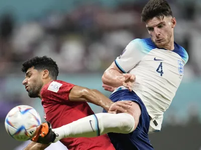 England's Declan Rice, right, kicks the ball past Iran's Mehdi Taremi during the World Cup group B soccer match between England and Iran at the Khalifa International Stadium in Doha, Qatar, Monday, Nov. 21, 2022. (AP Photo/Abbie Parr)