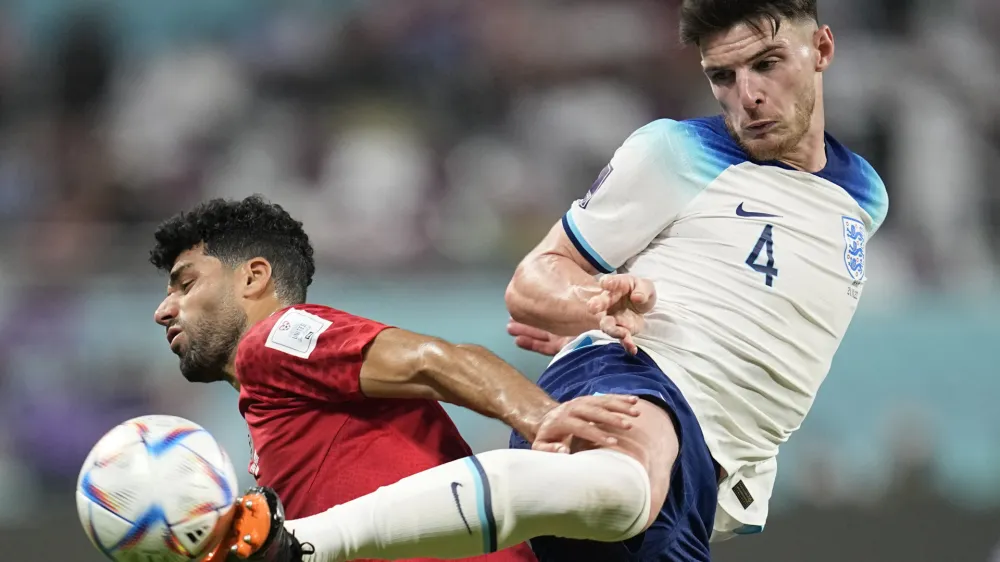 England's Declan Rice, right, kicks the ball past Iran's Mehdi Taremi during the World Cup group B soccer match between England and Iran at the Khalifa International Stadium in Doha, Qatar, Monday, Nov. 21, 2022. (AP Photo/Abbie Parr)