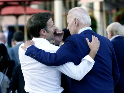 FILE - French President Emmanuel Macron whispers to U.S. President Joe Biden following their dinner at the G7 Summit in Elmau, Germany, June 26, 2022. Macron is heading to Washington for the first state visit of Biden's presidency&mdash;a reviving of diplomatic pageantry that had been put on hold because of the COVID-19 pandemic. (AP Photo/Susan Walsh, File)