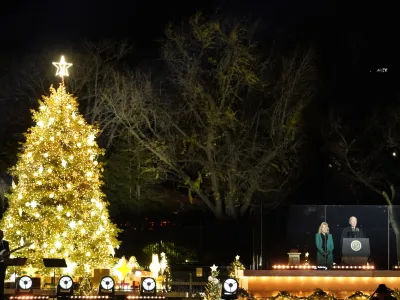 President Joe Biden speaks as first lady Jill Biden listens during the National Christmas Tree lighting ceremony on the Ellipse, near the White House in Washington, Wednesday, Nov. 30, 2022. (AP Photo/Alex Brandon)