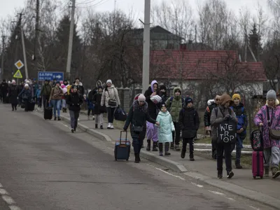Groups of Ukrainian refugees walk along the road between Lviv and Shehyni, in Volytsya, Ukraine, Saturday March 5, 2022. The number of Ukrainians forced from their country since the Russian invasion has been increasing on a daily basis. (AP Photo/Marc Sanye)