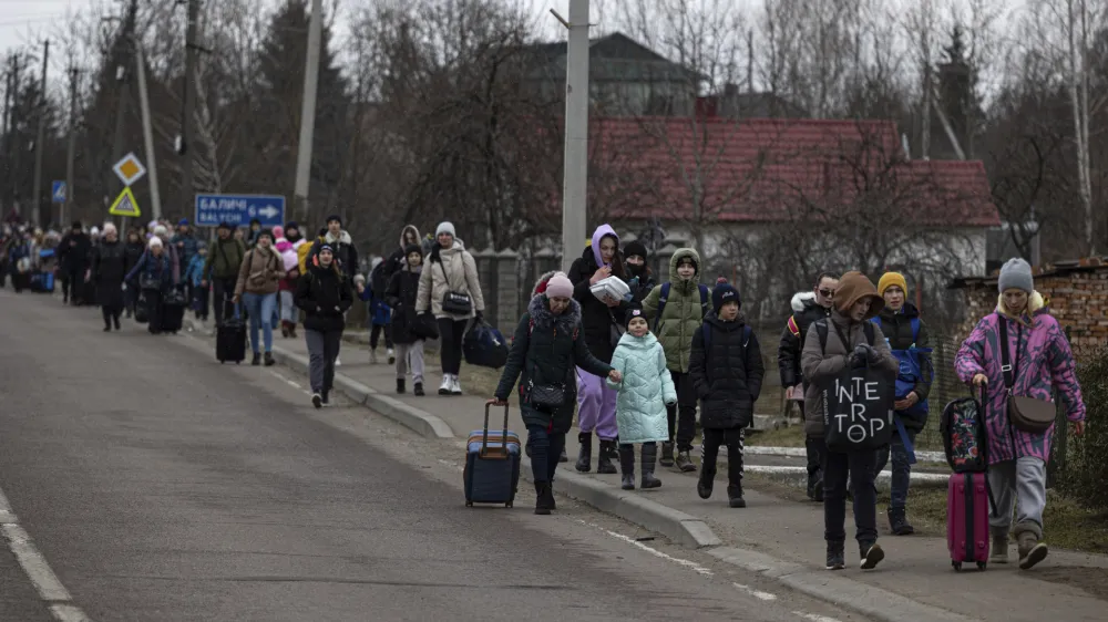 Groups of Ukrainian refugees walk along the road between Lviv and Shehyni, in Volytsya, Ukraine, Saturday March 5, 2022. The number of Ukrainians forced from their country since the Russian invasion has been increasing on a daily basis. (AP Photo/Marc Sanye)