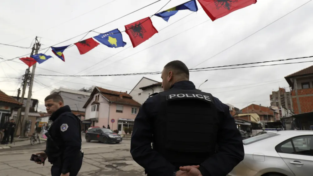 Kosovo police officers guard a street in northern, Serb-dominated part of ethnically divided town of Mitrovica, Kosovo, Friday, Dec. 9, 2022. On Thursday, police increased their presence in the four ethnic Serb-dominated communes in the north, where snap election will be held Dec. 18 following the abandonment of local posts by ethnic Serb minority representatives. (AP Photo/Bojan Slavkovic)