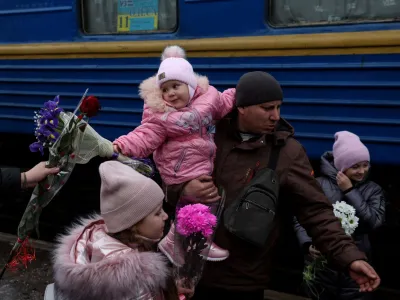 Children are greeted with flowers after arriving at the railway station, as Russia's attack on Ukraine continues, in the Donetsk Oblast region of Kramatorsk, Ukraine, December 10, 2022. REUTERS/Shannon Stapleton