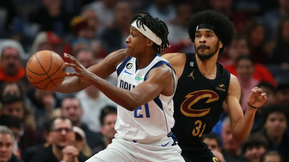 Dec 17, 2022; Cleveland, Ohio, USA; Dallas Mavericks guard Frank Ntilikina (21) passes the ball against Cleveland Cavaliers center Jarrett Allen (31) in the second half at Rocket Mortgage FieldHouse. Mandatory Credit: Aaron Josefczyk-USA TODAY Sports