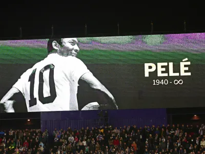 Fans sit beneath a giant screen during a minute of silence for Pel&eacute; before the start of a Spanish La Liga soccer match between Valladolid and Real Madrid at the Jose Zorrilla stadium in Valladolid, Spain, Friday, Dec. 30, 2022. Pel&eacute;, the Brazilian king of soccer who won a record three World Cups and became one of the most commanding sports figures of the last century, died in Sao Paulo on Thursday. He was 82. (AP Photo/Pablo Garcia)