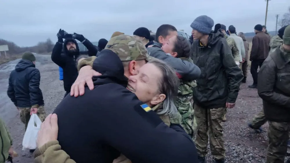 A woman embraces a Ukrainian prisoner of war (POWs) after a swap, amid Russia's attack on Ukraine, in an unknown location, Ukraine December 31, 2022. Head of Ukraine's Presidential Office Andriy Yermak via Telegram/Handout via REUTERS ATTENTION EDITORS - THIS IMAGE HAS BEEN SUPPLIED BY A THIRD PARTY. NO RESALES NO ARCHIVE.