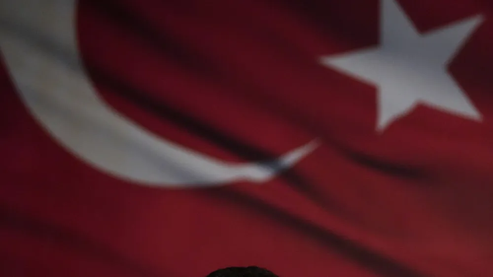 Istanbul Mayor Ekrem Imamoglu looks towards his supporters while they gather in front of the municipal building in Istanbul, Thursday, Dec. 15, 2022. Thousands of people gathered outside the Istanbul municipal building for a second day on Thursday to denounce a legal verdict that could lead to the city's popular mayor being ousted from office and barred from running in elections next year. (AP Photo/Khalil Hamra)