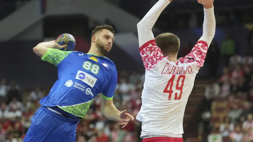 Poland's Piotr Chrapkowski, right, tries to block a shot of Slovenia's Aleks Vlah during the group B, Handball World Championship match between Poland and Slovenia in Katowice, Poland, Saturday, Jan. 14, 2023. (AP Photo/Piotr Hawalej)
